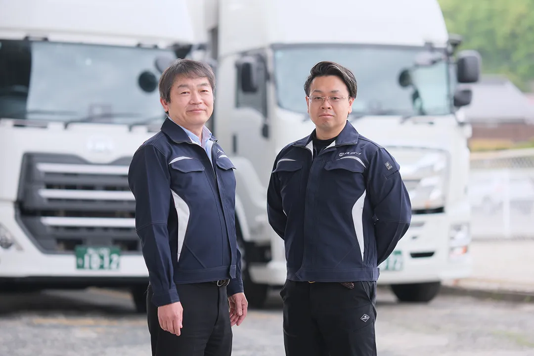 大型トラックの前に立つ代表取締役と専務