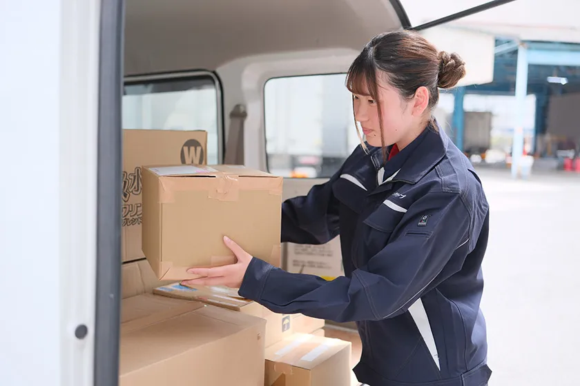 配送車に荷物を一つひとつ確認しながら積み込むスタッフ