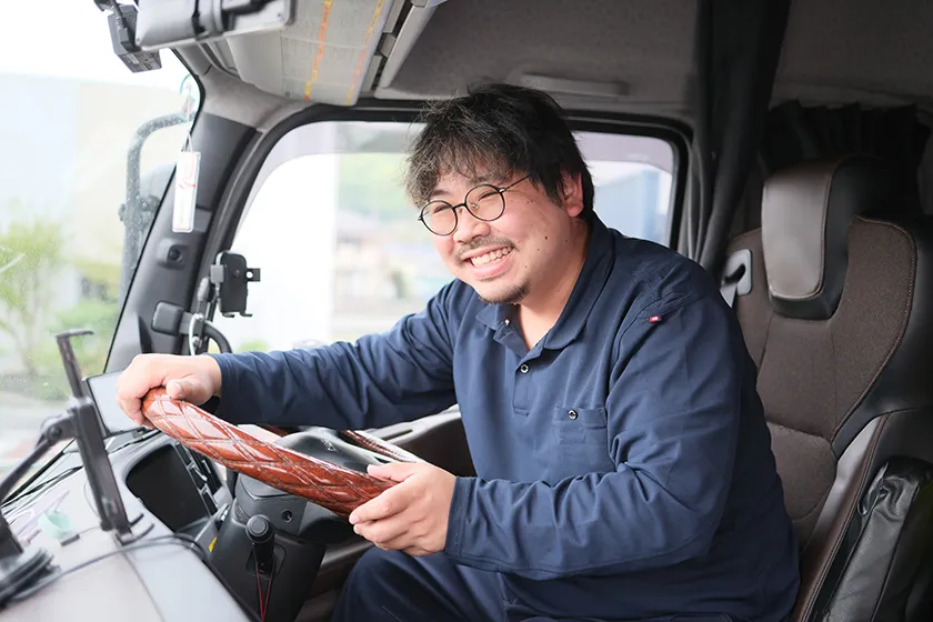 運転席で笑顔を見せるドライバー