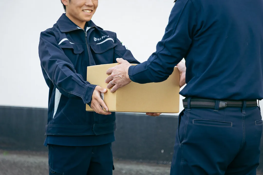 荷物を一つひとつ丁寧に手渡しで受け渡すスタッフ