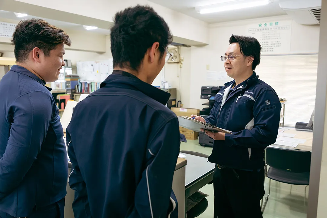事務所で先輩が若手に指導する研修の様子