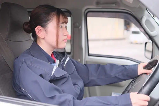 軽貨物車を運転する女性ドライバー
