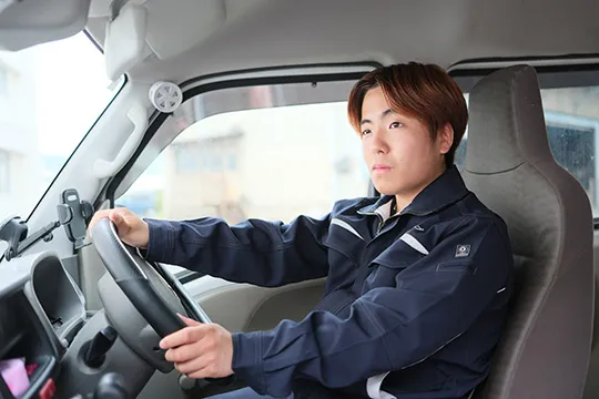 軽トラックの運転席に座る若手ドライバー