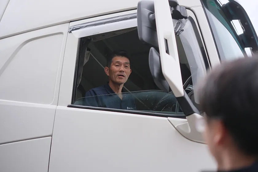 運転席の窓越しに言葉を交わすドライバー