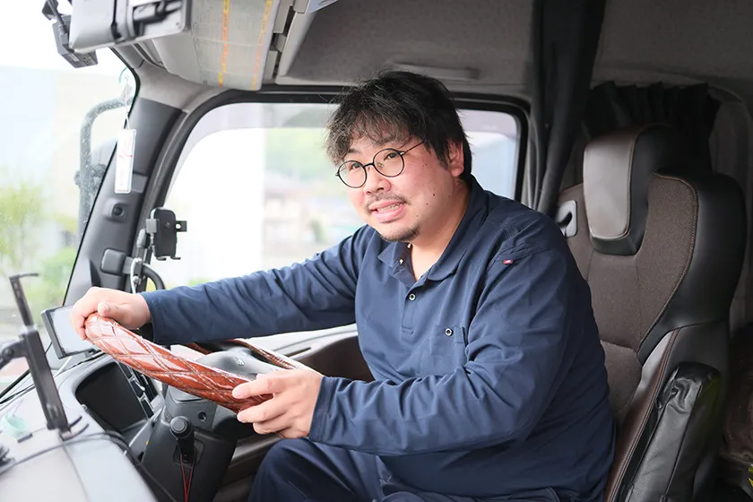 運転席で笑顔を見せるドライバー